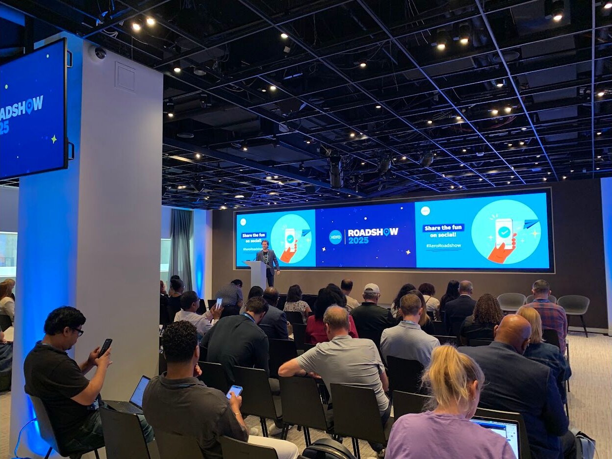 A full Roadshow audience watching a speaker on stage